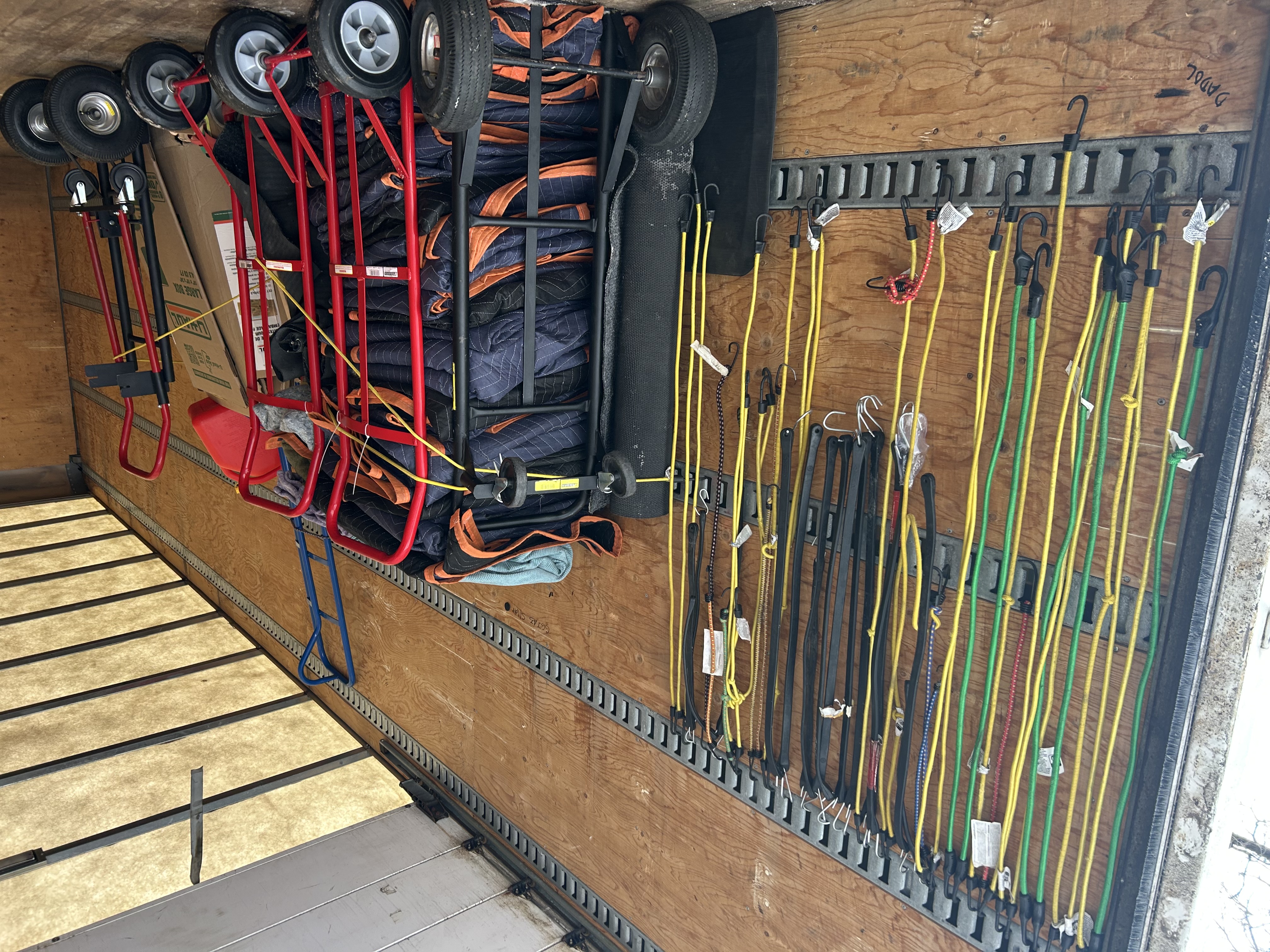 Moving equipment, dollies, pads, and straps ready in a truck